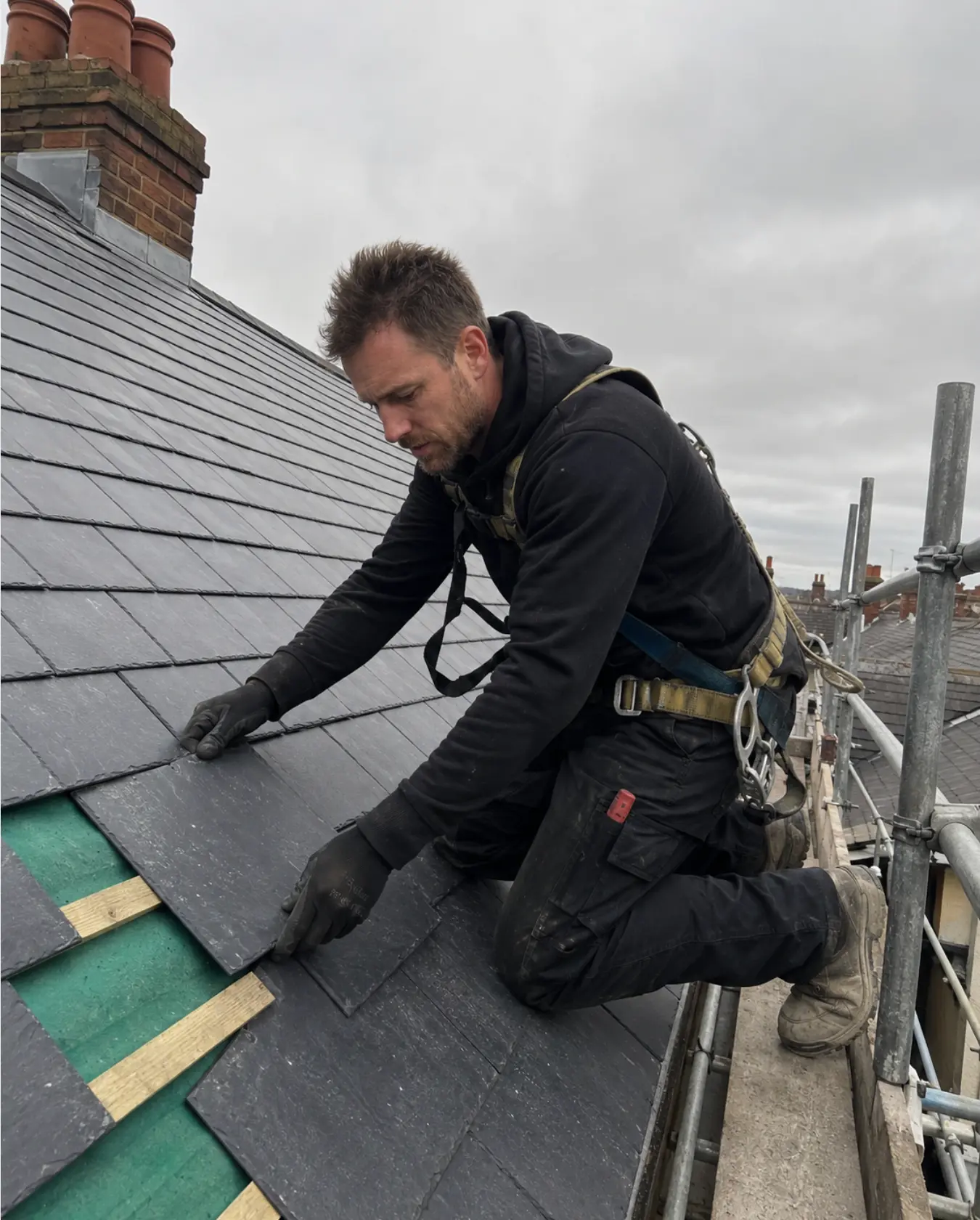 ProTech roofer laying natural slate on a scaffolded period roof