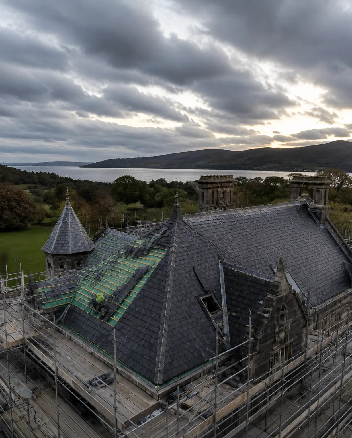 Aerial view of a storm-damaged heritage slate roof under scaffolding and restoration